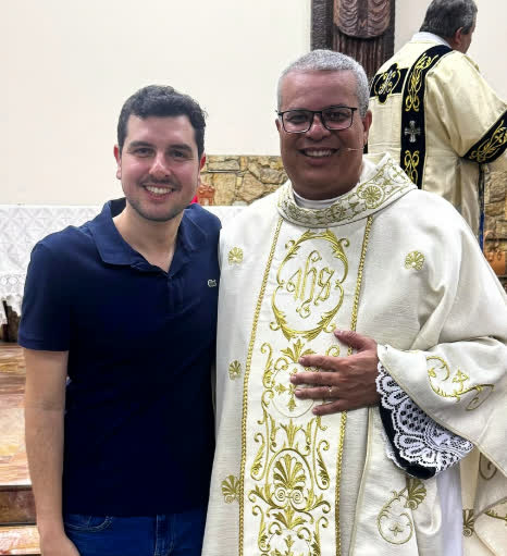 Bruno Vassari ao lado de um padre em uma igreja da cidade